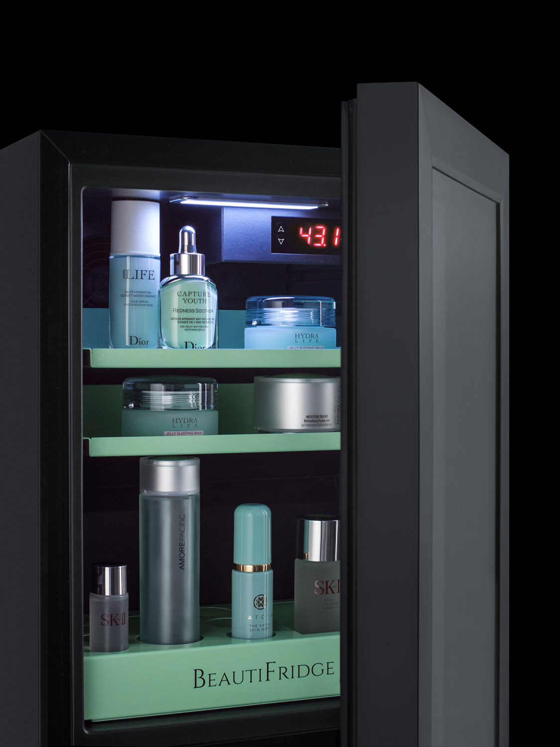 BeautiFridge compact cosmetics cooler with glass door, black cabinet, lock, glossy mint-colored shelves, and digital controls set for the storage of beauty products